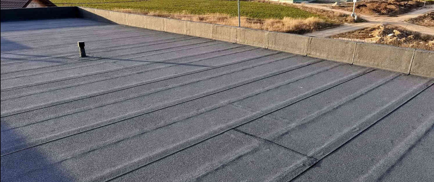 Płaski dach pokryty papą termozgrzewalną z kominkiem wentylacyjnym, widok z góry, Łódź.