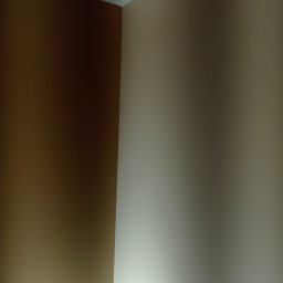 San Remont Gips Usługi Remontowo-Wykonczeniowe Adrian Rosak - Pomieszczenie z pomalowanymi ścianami na kolor brązowy i beżowy, widoczne łączenie ścian i sufitu.