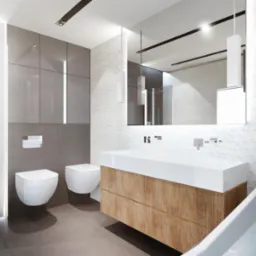 Nowoczesna łazienka z podwieszanymi toaletami, umywalką z szafką z drewnianymi frontami i białą wanną, wykończona szarą glazurą i białą, trójwymiarową mozaiką.