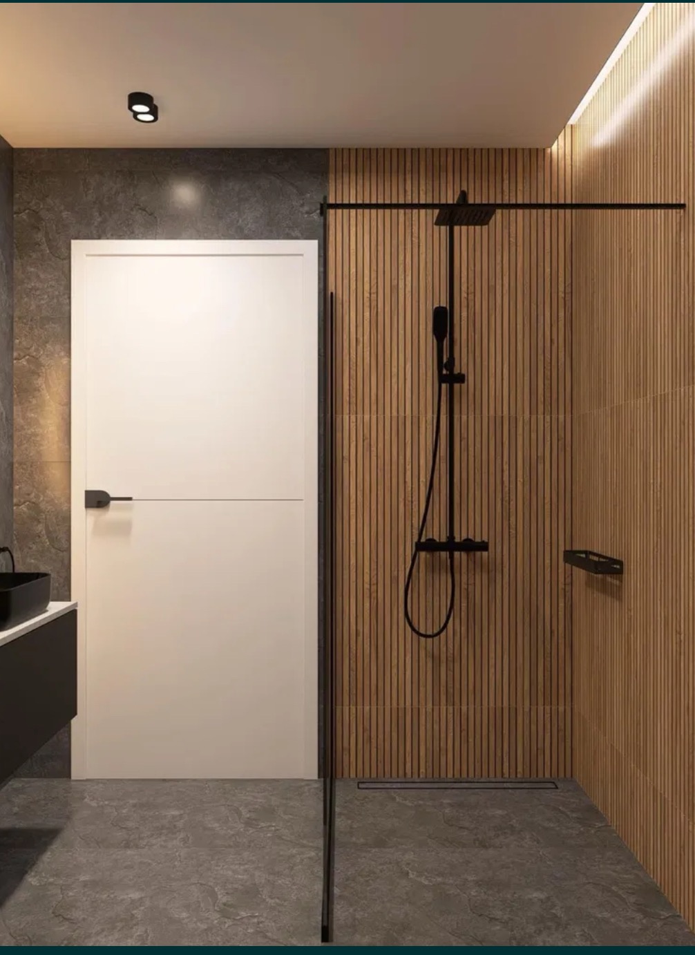 Nowoczesna łazienka z drewnianymi panelami ściennymi, kabiną prysznicową typu walk-in z czarną armaturą i białą, minimalistyczną umywalką na tle szarej ściany.