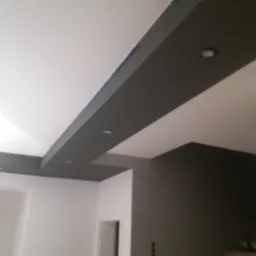 Pomieszczenie po remoncie z pomalowanym sufitem z elementami podwieszanymi w kolorze szarym i zamontowanymi punktowymi źródłami światła