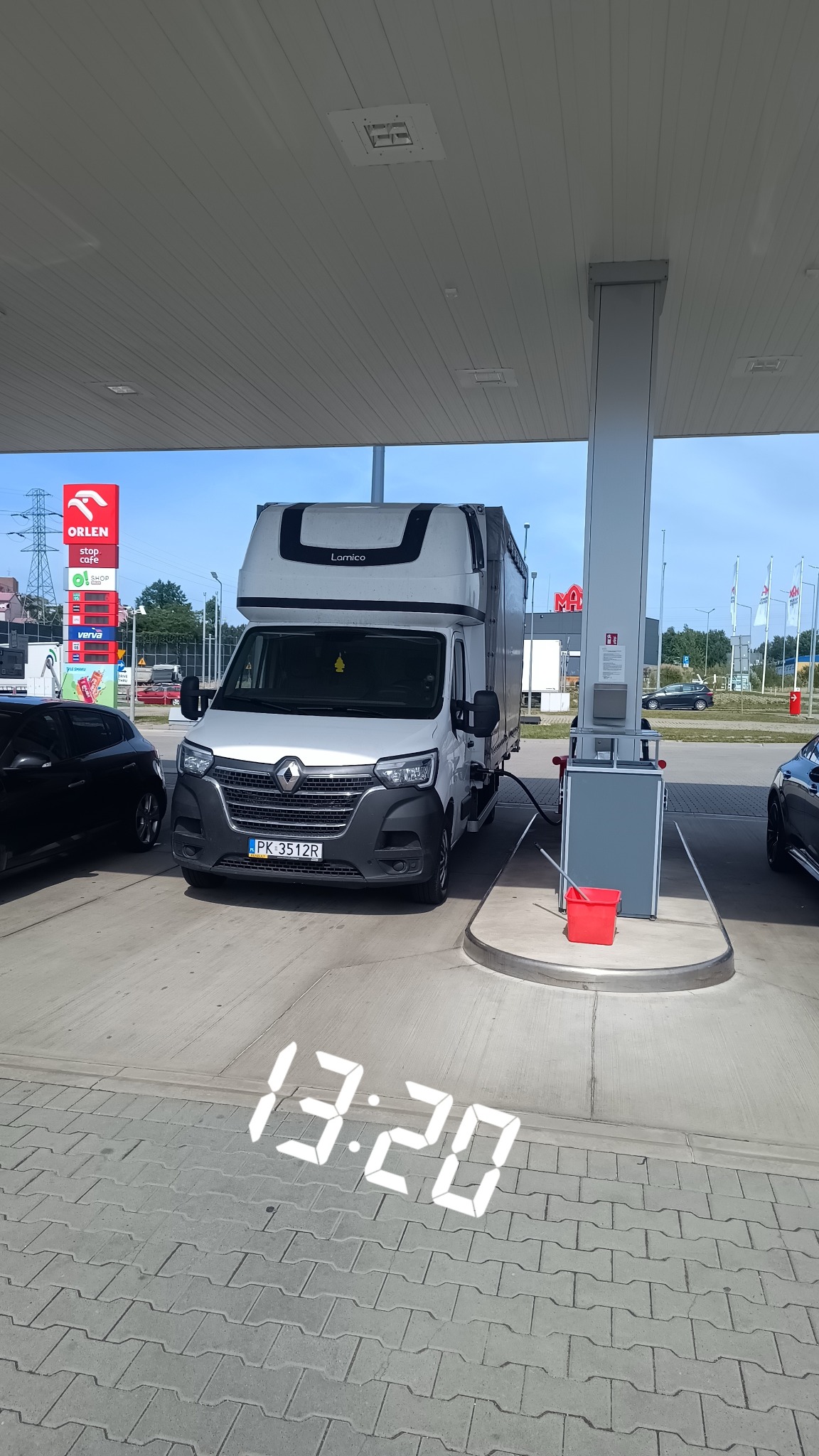 Biały bus z zabudową Lamico, zatankowany na stacji Orlen, widoczny numer rejestracyjny PK 3512R i zapach samochodowy pod lusterkiem.