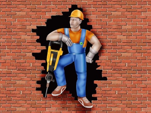 Karykaturalny murarz w kasku opiera się o wiertarkę udarową, stojąc w otworze wybitym w ceglanej ścianie.