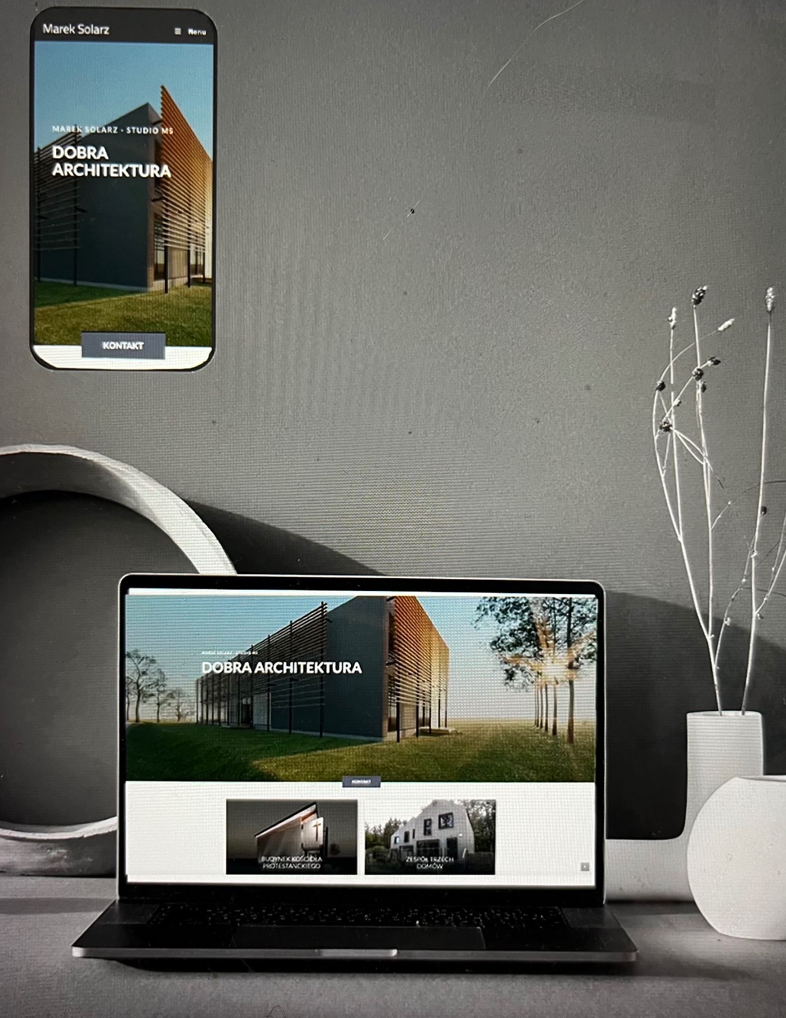 Prezentacja strony internetowej architekta Marka Solarza na ekranie laptopa i smartfona, widoczna nazwa domeny 'Dobra Architektura'.