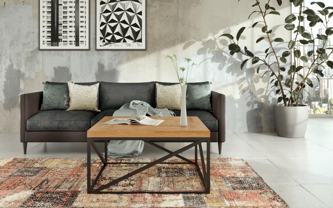 Salon z szarą sofą, drewnianym stolikiem kawowym z metalową podstawą, wzorzystym dywanem i rośliną w donicy, oświetlony naturalnym światłem.