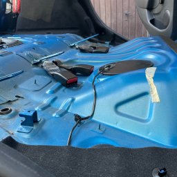 Scars Detailing - Wnętrze samochodu zdemontowane do czyszczenia, widoczne niebieskie blachy podłogowe, pasy bezpieczeństwa i elementy instalacji elektrycznej.