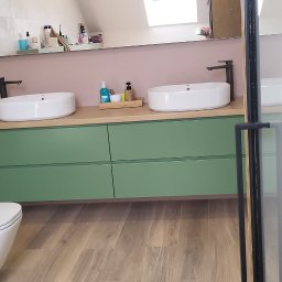 RD MEBLE Meble na wymiar Rafał Kacprzak - Nowoczesna łazienka z zielonymi szafkami pod umywalkami, drewnianym blatem, białymi umywalkami nablatowymi i wiszącą toaletą.