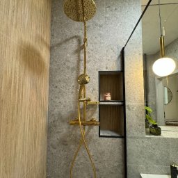 Oleksandr Nazarow - Nowoczesna łazienka z deszczownicą w kolorze złotym, szare płytki imitujące kamień i wnęka z półkami.