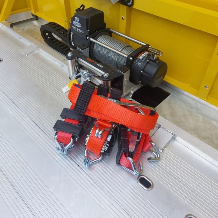 Elektryczna wciągarka linowa TS 9500 z pomarańczowymi pasami mocującymi na aluminiowej platformie transportowej, widok z góry.