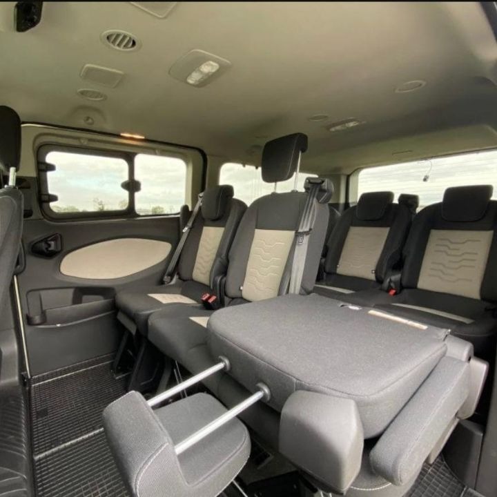 Wnętrze przestronnego busa z rozłożonymi fotelami pasażerskimi w Malborku, widok z tyłu pojazdu, ukazujący komfortowe warunki podróży.