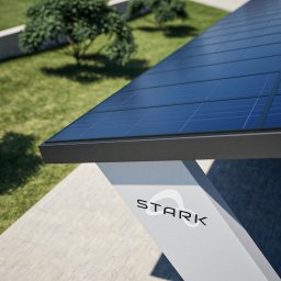 STARK SPÓŁKA Z OGRANICZONĄ ODPOWIEDZIALNOŚCIĄ - Nowoczesna, minimalistyczna konstrukcja z paneli słonecznych z logo 'STARK' na białej podstawie, na tle zielonego trawnika z drzewem.