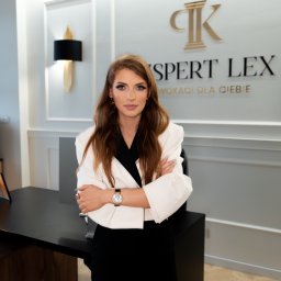 Kancelaria Adwokacka Adwokat Mediator Karolina Pająk Rozwód Alimnety Majątek - Kobieta w białym żakiecie, skrzyżowane ręce, na tle biura z logo 'Ekspert Lex'. Profesjonalny wizerunek prawnika w nowoczesnym wnętrzu kancelarii.