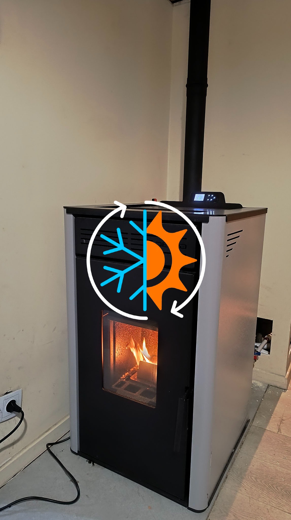 Piec na pellet Defro 8kW z instalacją grzejnikową, umieszczony w przestrzeni użytkowej. Widoczny płomień i grafika słońca/śnieżynki symbolizująca ogrzewanie.