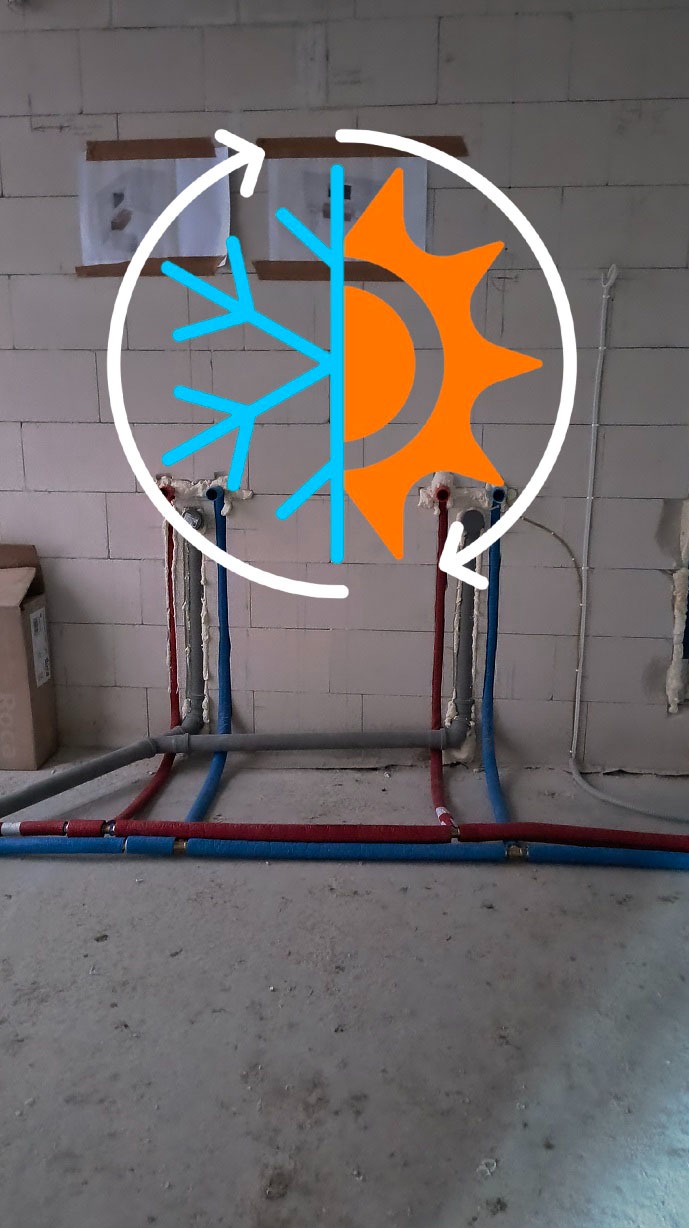 Instalacja wodno-kanalizacyjna w surowym stanie, z widocznymi rurami w kolorach niebieskim i czerwonym, z nałożoną grafiką słońca i śnieżynki w okręgu.