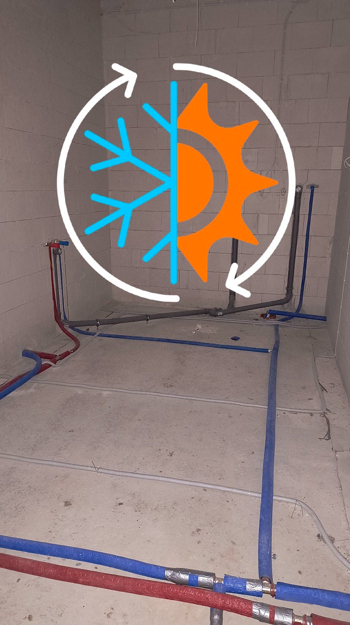 Instalacja wodno-kanalizacyjna w surowym pomieszczeniu z widocznymi rurami w kolorach niebieskim i czerwonym, z nałożoną grafiką słońca i płatka śniegu.