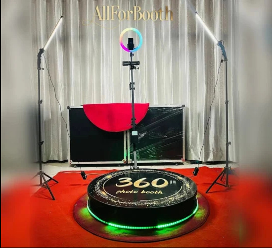 Okrągła platforma 360 stopni z napisem '360 photo booth', oświetlona zielonymi diodami LED, otoczona czerwonym dywanem, z dodatkowym oświetleniem LED i tłem, gotowa do użycia.