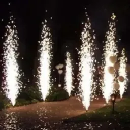 Fontanny iskier na ścieżce, wieczorowa dekoracja plenerowa z białymi balonami w tle, tworzące magiczną atmosferę.