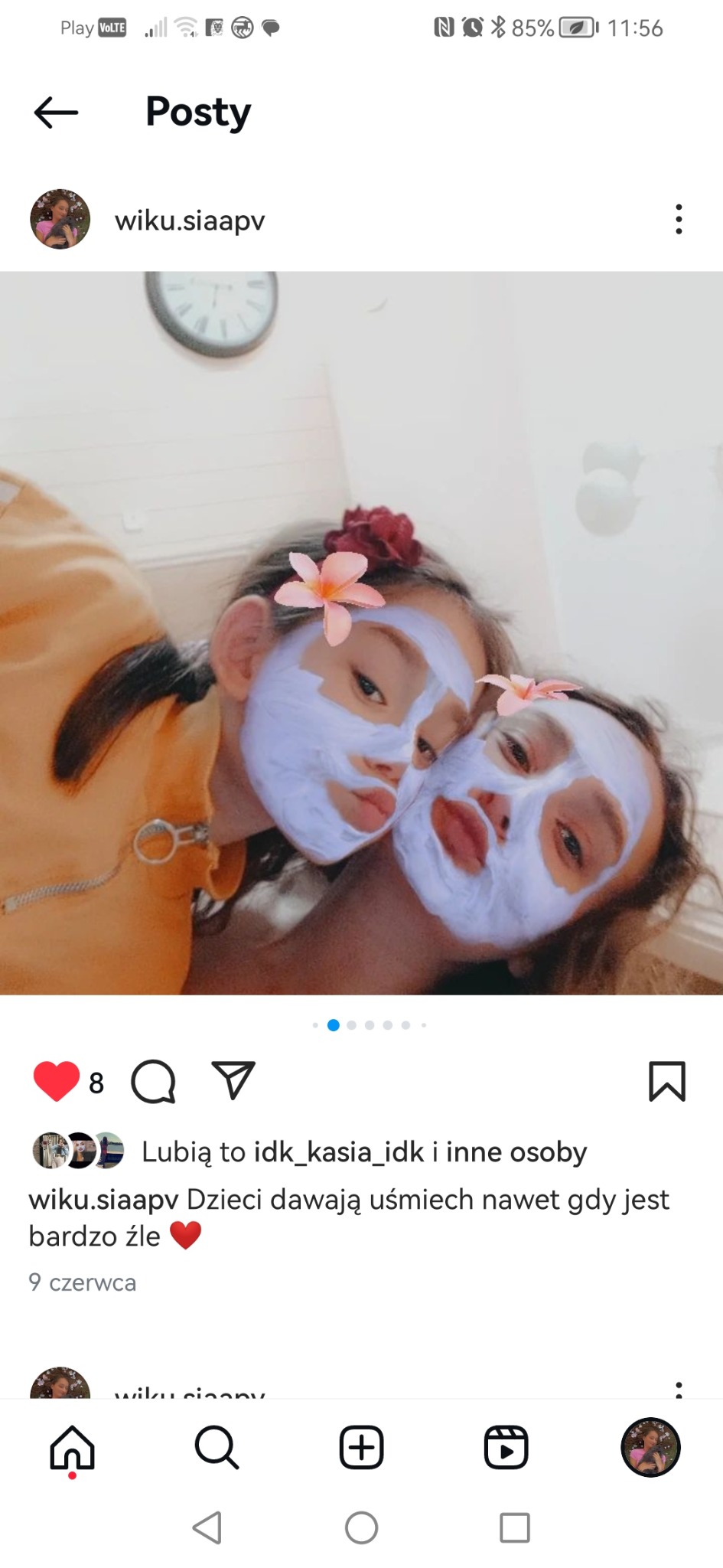 Dwie dziewczynki z maseczkami kosmetycznymi na twarzach, ozdobione kwiatami, ujęcie z bliska, widok z góry.