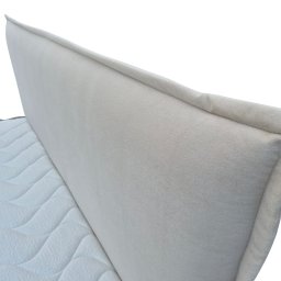 Fotello Meble Robert Śmiałek - Jasny, tapicerowany zagłówek łóżka z pikowanym materacem. Widoczny fragment boku i góry zagłówka. Ujęcie z bliska, ukazujące fakturę materiału.