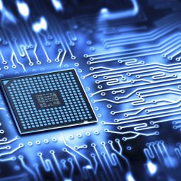 kompiki.pl Wojciech Rolak - Niebieski, podświetlony procesor na tle płyty głównej z wyraźnie zaznaczonymi ścieżkami. Układ scalony z licznymi pinami i centralnym rdzeniem.