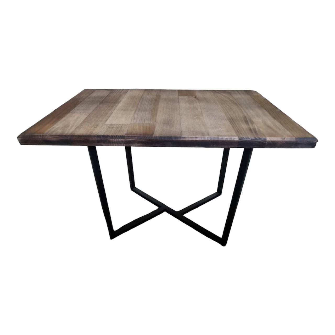 Kwadratowy stół z blatem z desek o zróżnicowanym odcieniu brązu i czarną, geometryczną podstawą wykonaną z metalowych profili, na białym tle.