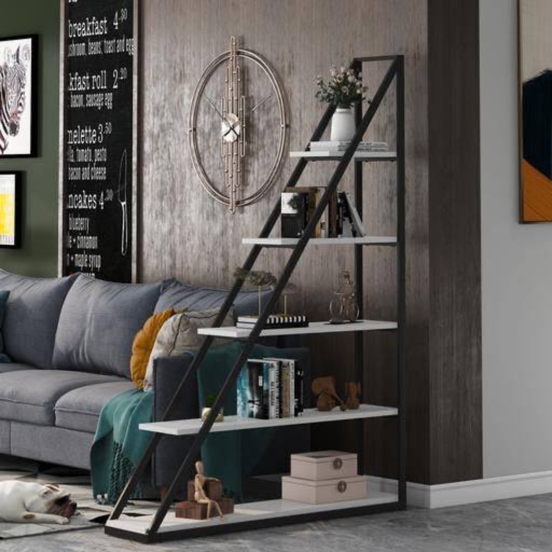Regał drabinkowy z czarną metalową ramą i białymi półkami, ustawiony w salonie z szarą sofą, dekoracjami i psem śpiącym na podłodze.