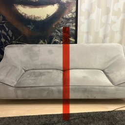 Perfect - firma sprzątająca Gdańsk Sopot Gdynia - Dwuosobowa szara sofa z widocznymi plamami, podzielona w pionie czerwoną linią, na tle wzorzystej tapety i zasłon.