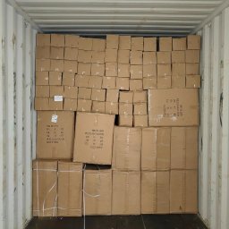 Relentless sp. z o.o. - Wnętrze kontenera wypełnione kartonowymi pudłami z widocznymi etykietami informacyjnymi o produkcie.