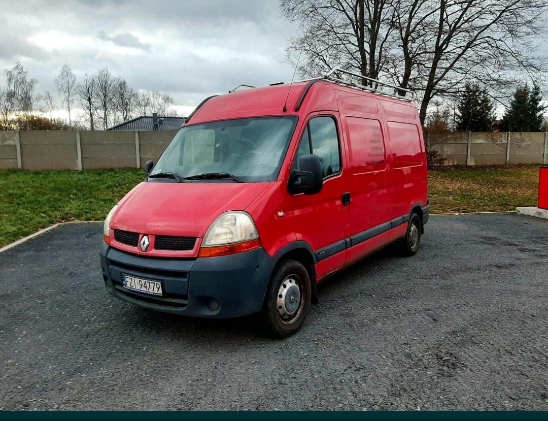 Czerwony Renault Master z relingami dachowymi, zaparkowany na asfaltowym placu, widoczny numer rejestracyjny FZI 94779.