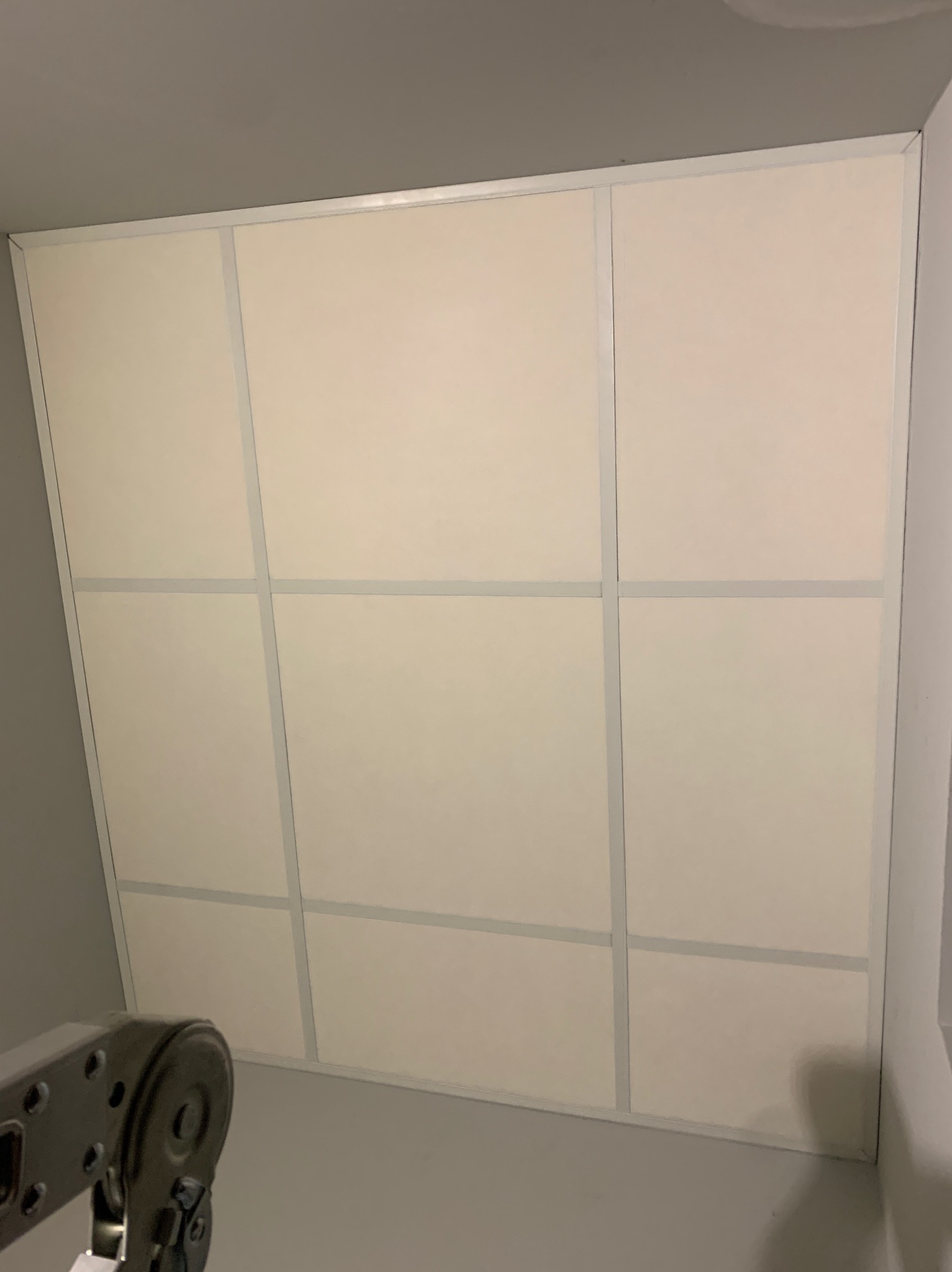 Zamontowany sufit z płyt kartonowo-gipsowych, widoczne 9 paneli z szarymi listwami oddzielającymi, z fragmentem drabiny w lewym dolnym rogu.