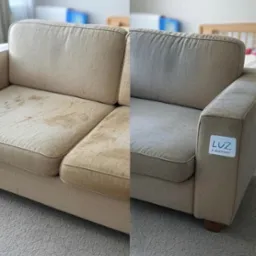 Beżowa kanapa: po lewej widoczne silne zabrudzenia, po prawej wyprana, czysta tapicerka. Efekt przed i po praniu. Na boku naklejka z logo firmy.