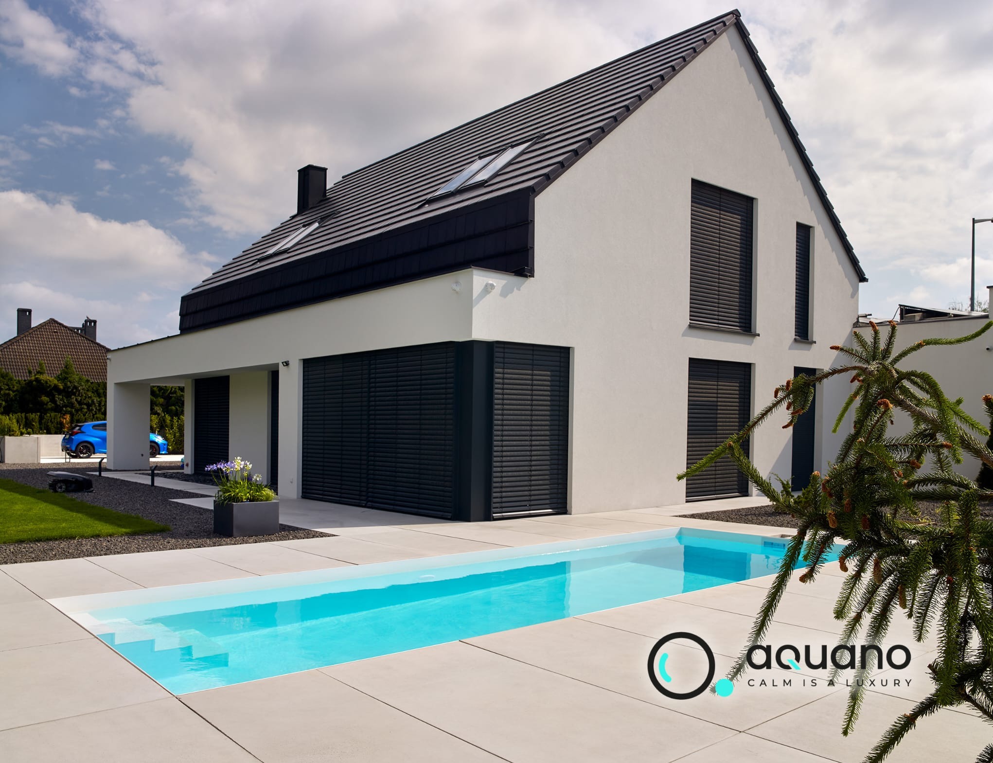 Nowoczesny dom z płaskim basenem, widoczne schody wejściowe do wody i logo firmy Aquano w prawym dolnym rogu.