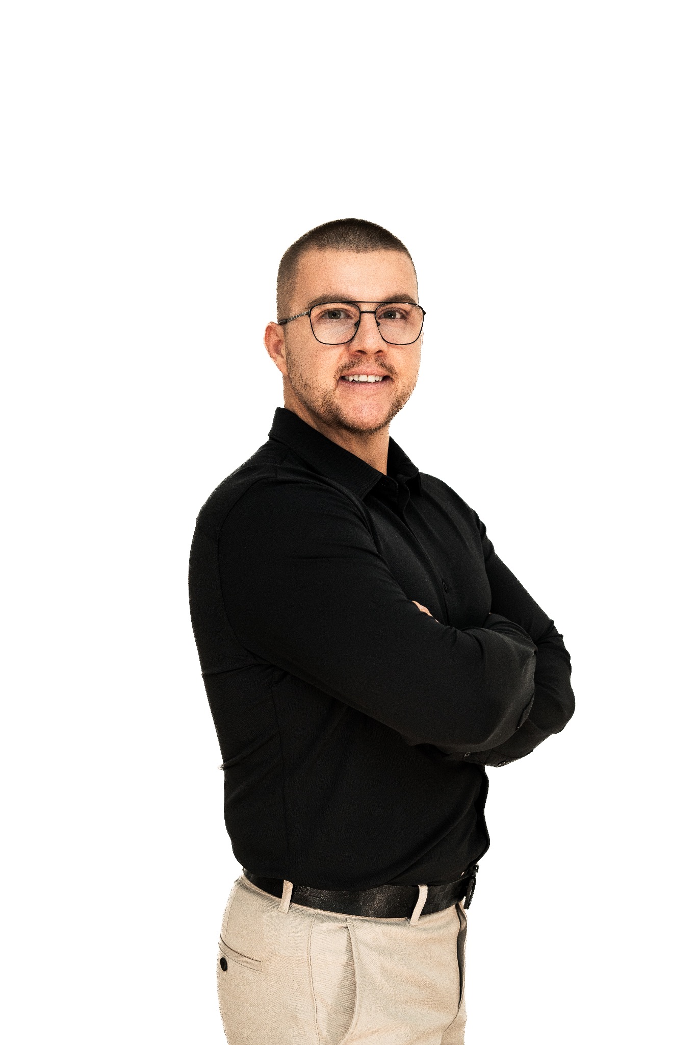 Uśmiechnięty mężczyzna w czarnej koszuli i okularach, z założonymi rękami na białym tle.
