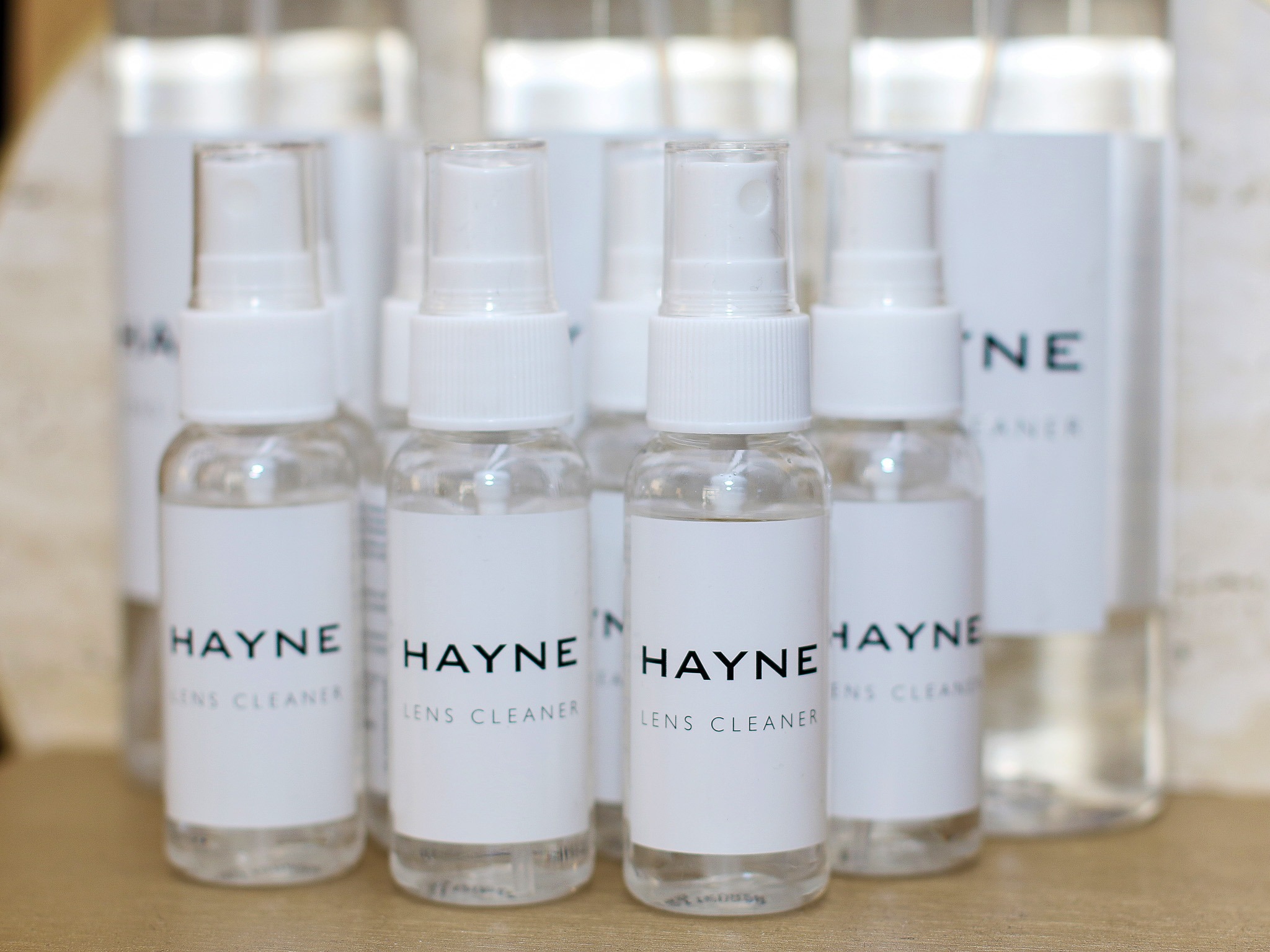 Butelki z płynem do czyszczenia soczewek kontaktowych marki HAYNE, dostępne w Gdańsku, ustawione w rzędzie na jasnym tle.