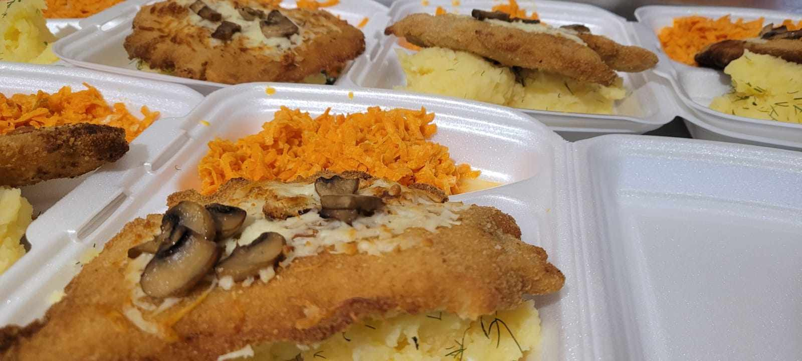 Dania obiadowe w styropianowych pojemnikach: kotlet schabowy z pieczarkami i serem, puree ziemniaczane z koperkiem oraz tarta marchewka.