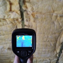 Firma Emil Urbański - Pomiar termowizyjny ściany ocieplonej wełną mineralną, widoczny na ekranie termowizyjnym kamery E5, wskazujący na potencjalne straty ciepła.