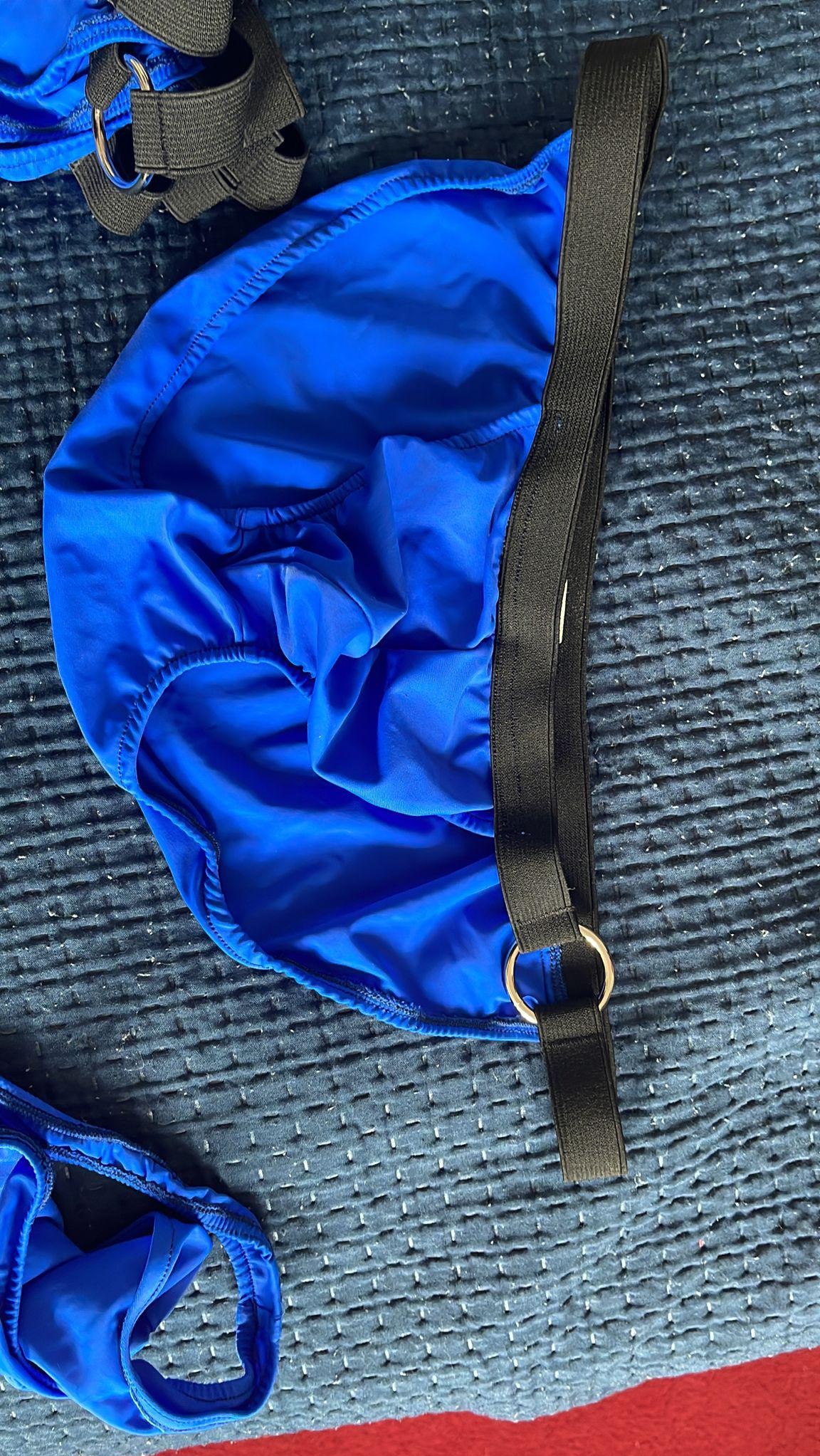 Jaskrawoniebieska, elastyczna bielizna z czarnymi paskami na teksturowanej, granatowej narzucie.