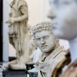 RafalSaduraFotograf.pl - Rząd marmurowych popiersi i figur w muzeum, z ostrym oświetleniem bocznym podkreślającym detale rzeźb.