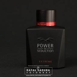 RafalSaduraFotograf.pl - Czarne, matowe opakowanie perfum Antonio Banderas Power of Seduction Extreme na ciemnym tle, z czerwonym akcentem na szyjce flakonu i subtelnym oświetleniem podkreślającym logo fotografa w dolnej...