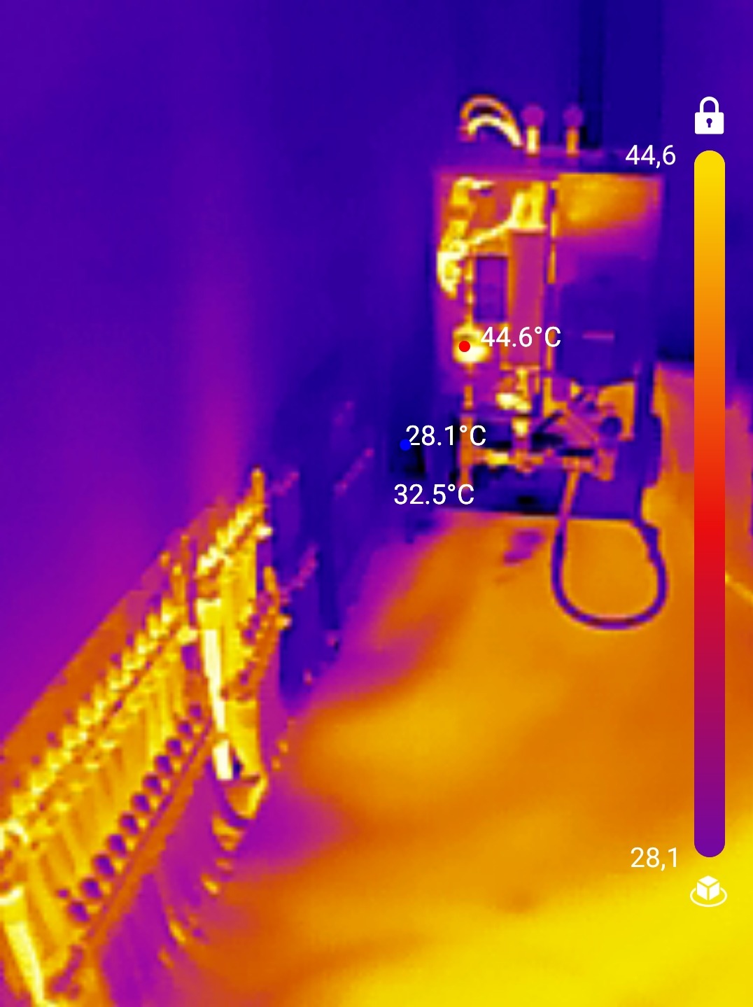 Termowizyjne zdjęcie instalacji grzewczej z zaznaczonymi temperaturami różnych elementów, widoczny rozdzielacz i inne komponenty.