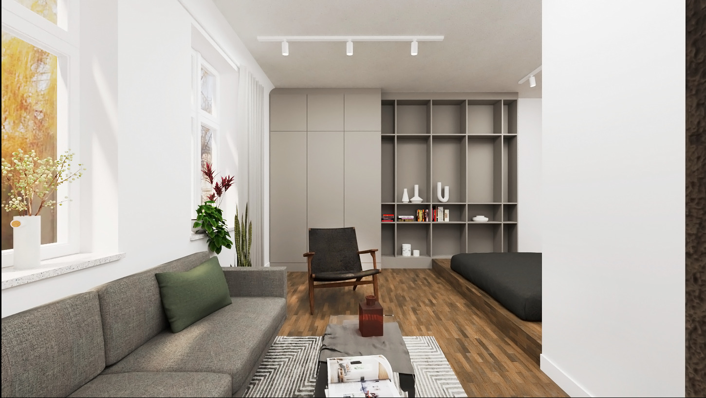 Jasne wnętrze mieszkania z szarą sofą z zieloną poduszką, drewnianym fotelem i regałem zabudowanym w ścianie z książkami i dekoracjami.