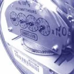 Zbliżenie na licznik energii elektrycznej z widocznymi wskazaniami zużycia. Na metalowej obudowie widnieją napisy i logo producenta.