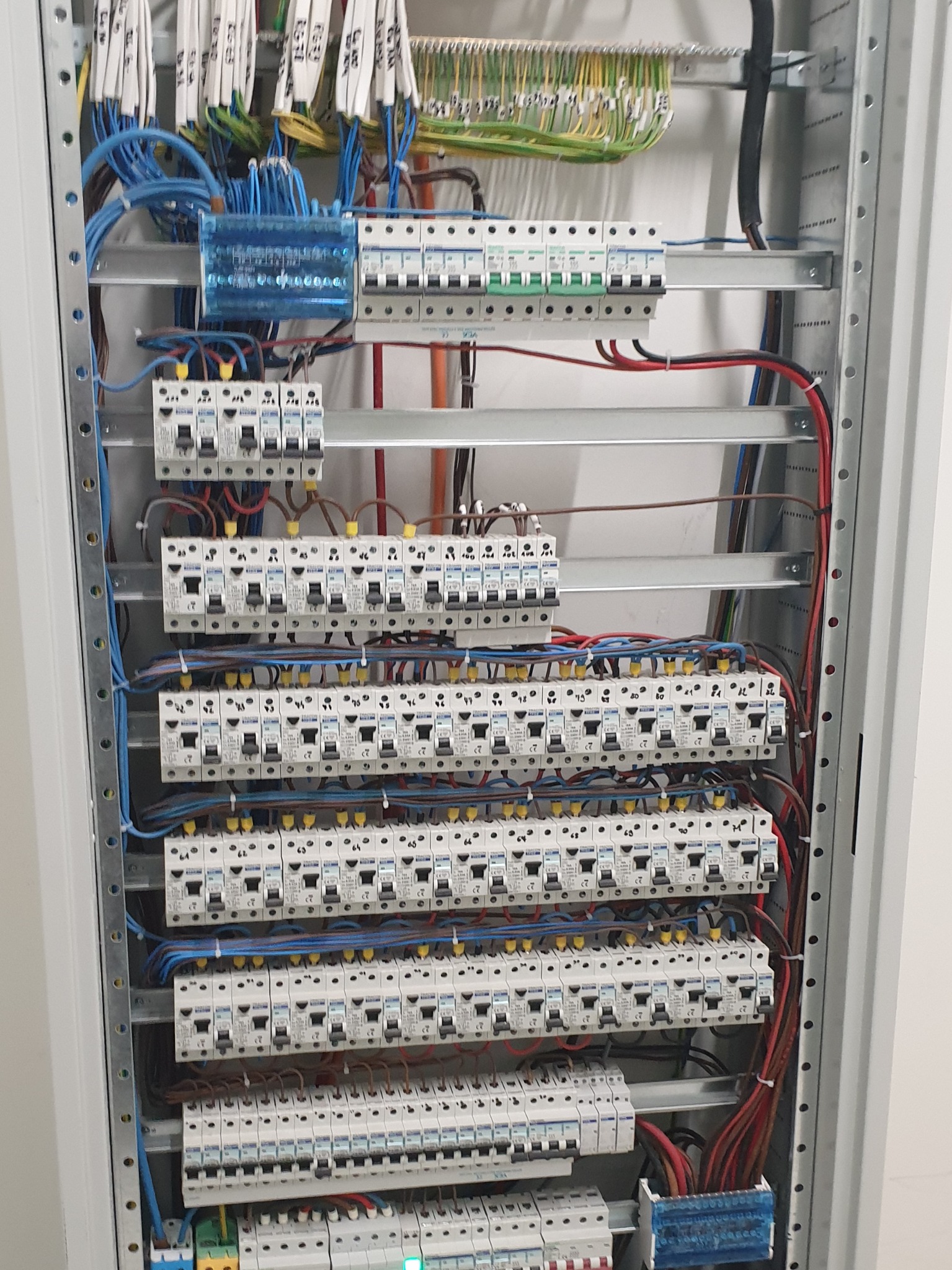 Rozdzielnica elektryczna z licznymi bezpiecznikami i okablowaniem, zainstalowana w Wilkszynie, widok z bliska na uporządkowany układ.