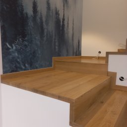 MK SCHODY Marcin Kowalczyk - Dębowe schody z tapetą leśną w tle, widoczne kable elektryczne w ścianie.