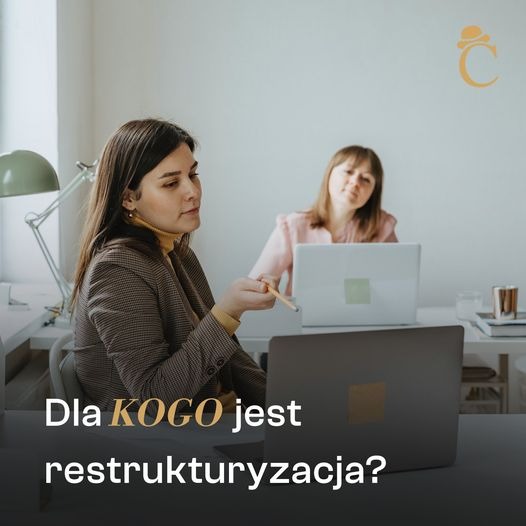 Dwie kobiety w biurze, jedna w brązowej marynarce z ołówkiem, druga w różowej bluzce z laptopem, dyskusja o restrukturyzacji.