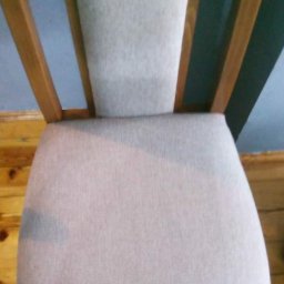 NT Detailing Profesjonalne Czyszczenie Tapicerki - Krzesło z jasną tapicerką, widoczne plamy po czyszczeniu, drewniana rama, ujęcie z góry.