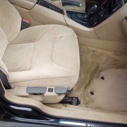 NT Detailing Profesjonalne Czyszczenie Tapicerki - Beżowa tapicerka fotela i dywanika w samochodzie marki Volvo, widoczne zabrudzenia przed i po czyszczeniu w Ostrowi Mazowieckiej.