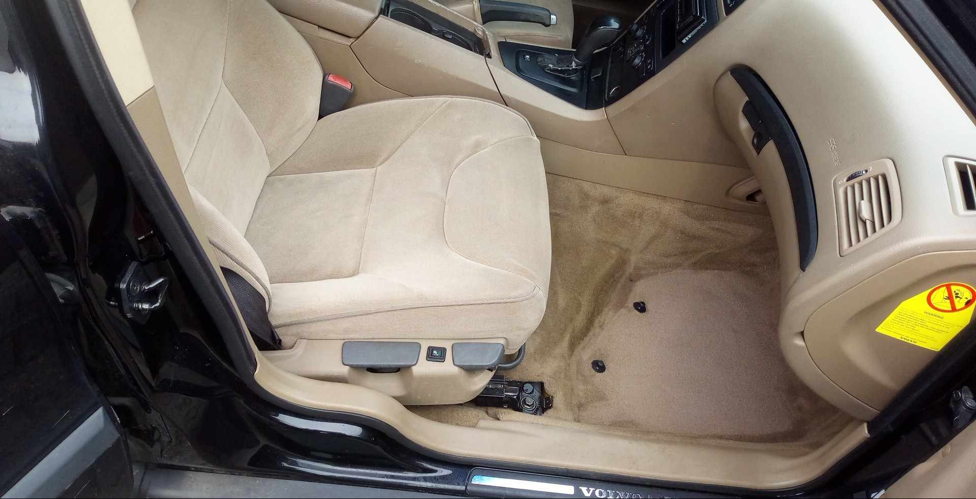 Beżowa tapicerka fotela i dywanika w samochodzie marki Volvo, widoczne zabrudzenia przed i po czyszczeniu w Ostrowi Mazowieckiej.