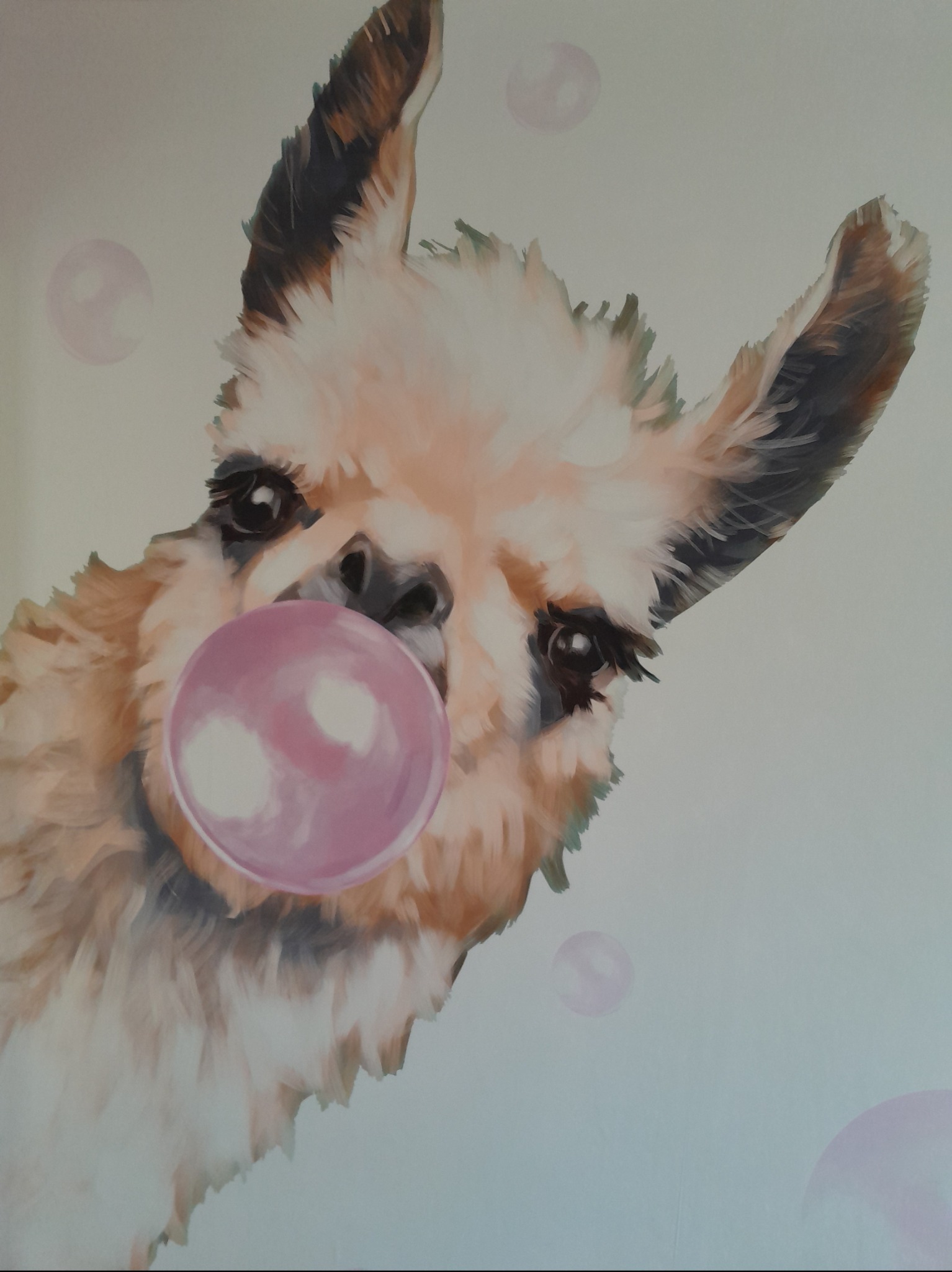 Ściana ozdobiona malunkiem lamy dmuchającej różową gumę balonową, otoczonej przez unoszące się bańki mydlane.