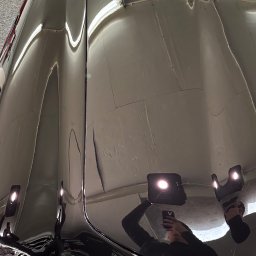 Brand New Car - Błyszcząca, czarna karoseria samochodu po polerowaniu, z widocznym odbiciem osoby robiącej zdjęcie telefonem.